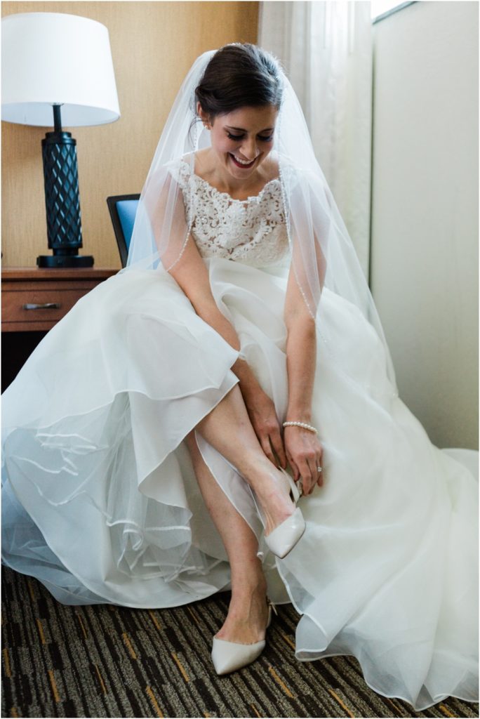 Bride putting on her shoes at the hotel before the wedding ceremony