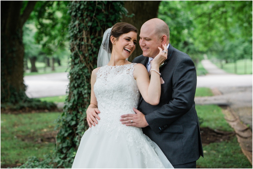 Candid moment of bride and groom laughing in Tower Grove Park