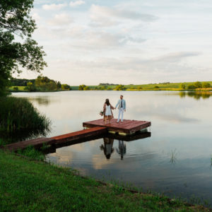 Bride and groom on a dock at sunset