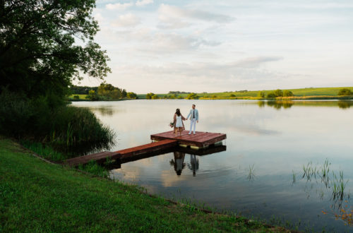Bride and groom on a dock at sunset