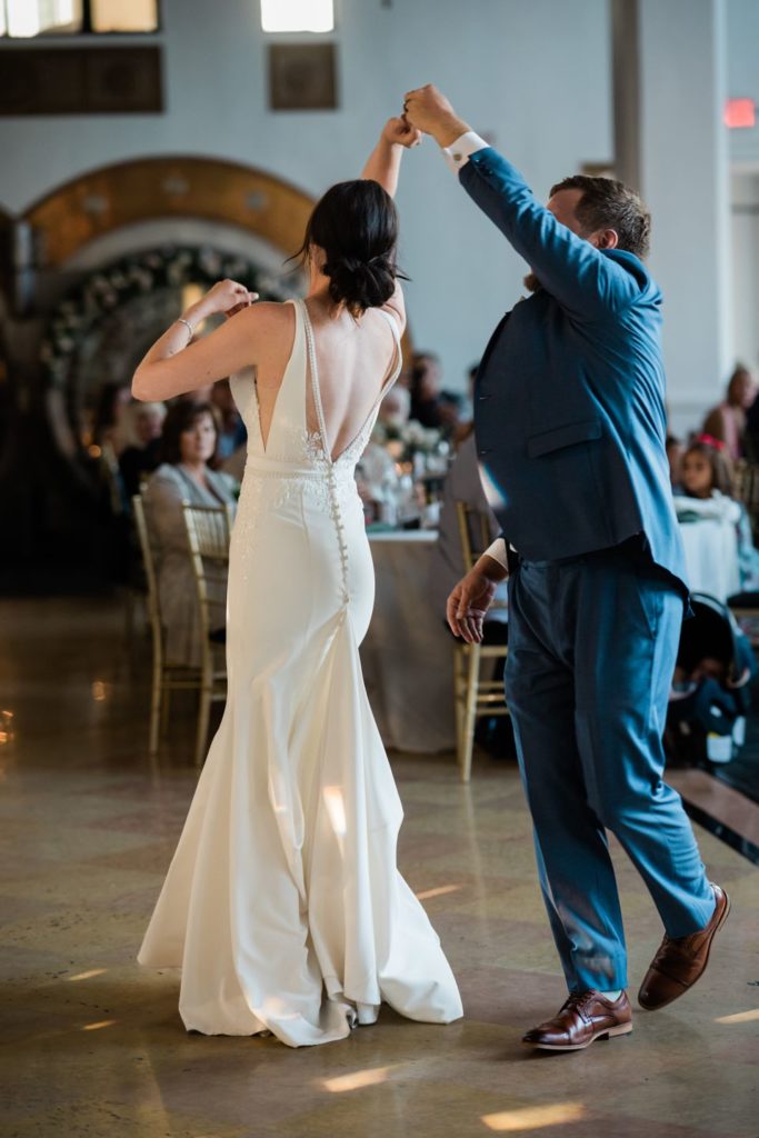 Groom twirling bride during their first dance